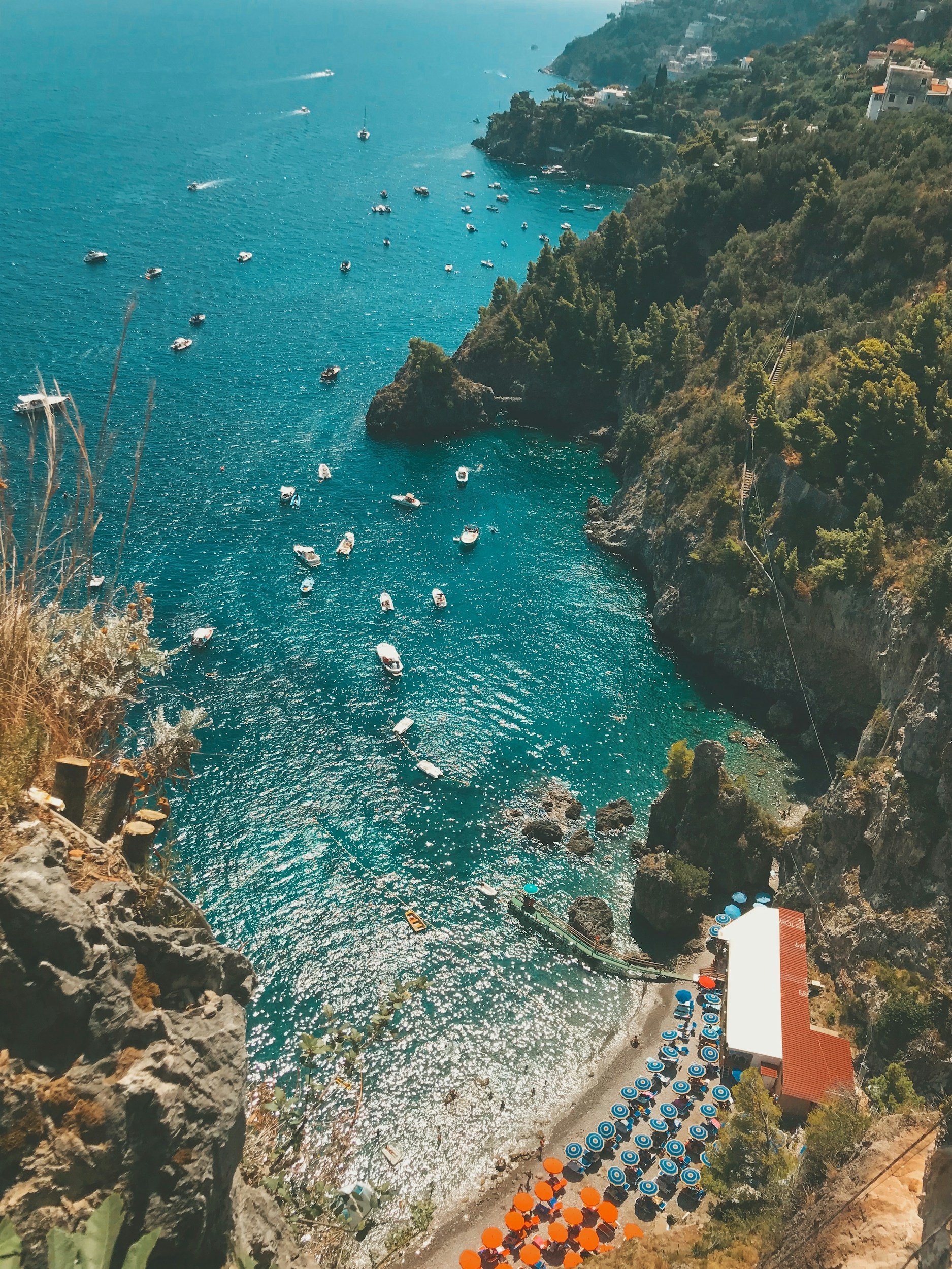 Pastel houses stacked on a cliffside above the turquoise Mediterranean on the Amalfi Coast