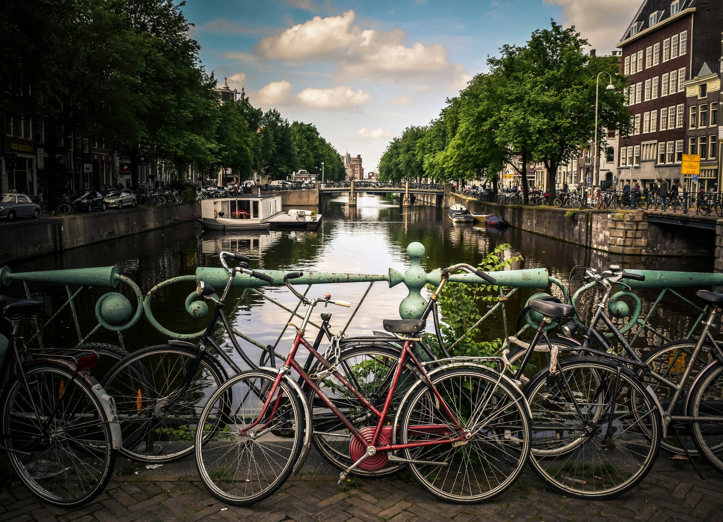 A canal lined with narrow gabled townhouses and an arched bridge in central Amsterdam