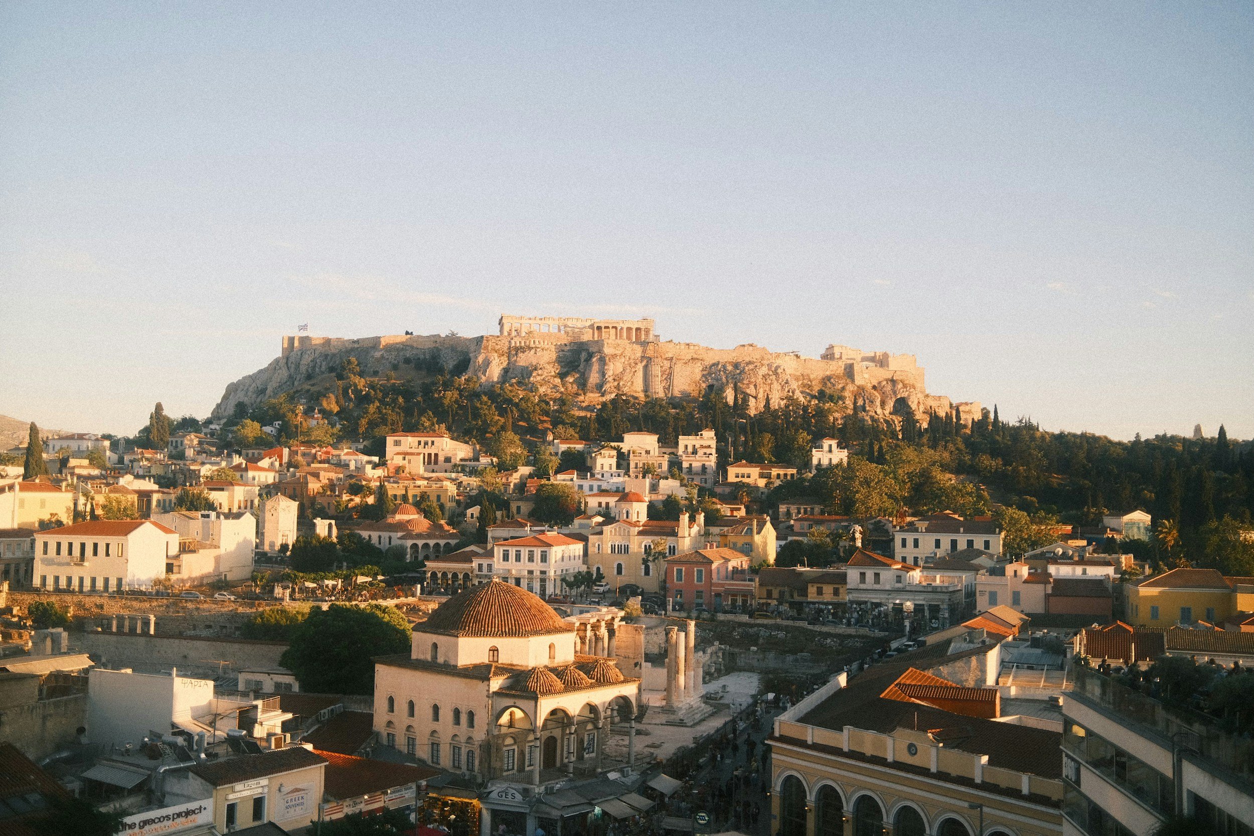 The Acropolis above Athens rooftops in warm late-day light