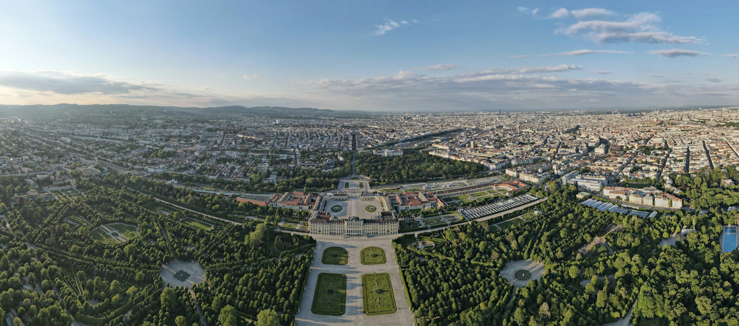 Aerial view of Schönbrunn Palace and its formal gardens with Vienna spreading beyond
