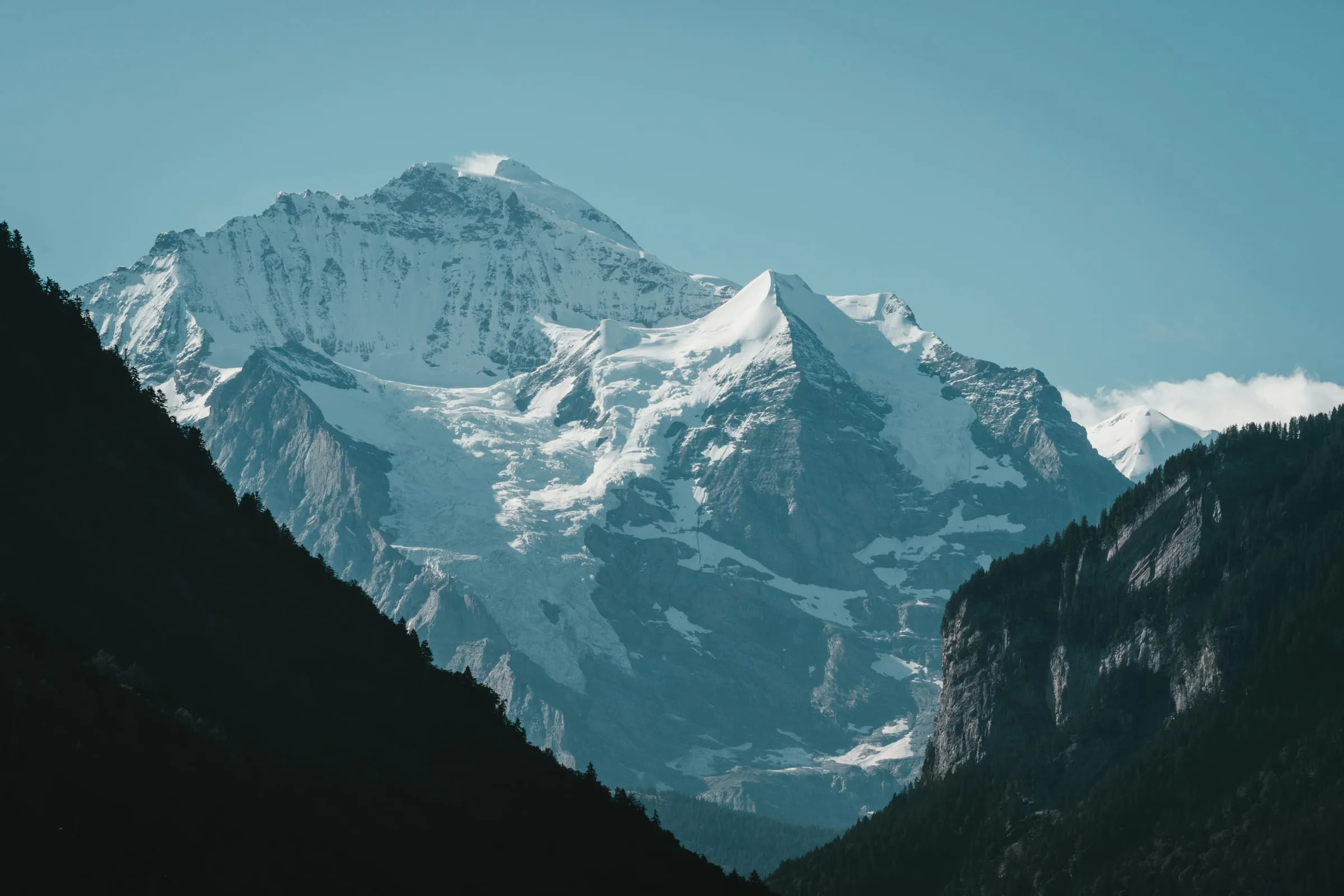 Snow-capped alpine peaks rising above green meadows in the Jungfrau region of Switzerland