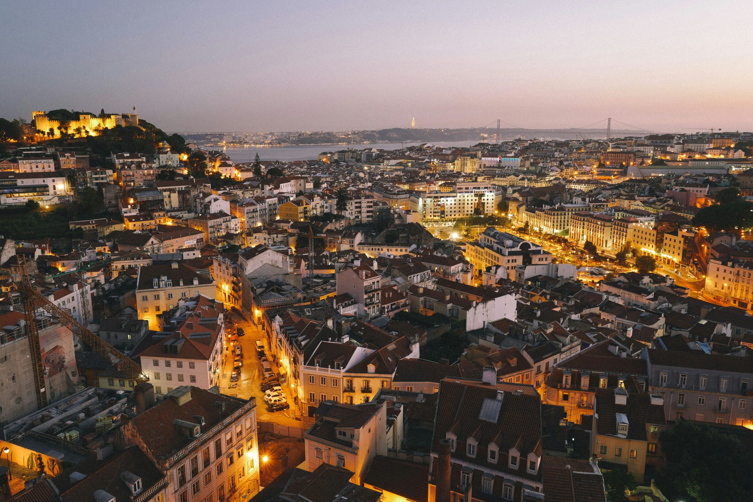 Pastel hillside houses and terracotta rooftops above the Tagus River in Lisbon