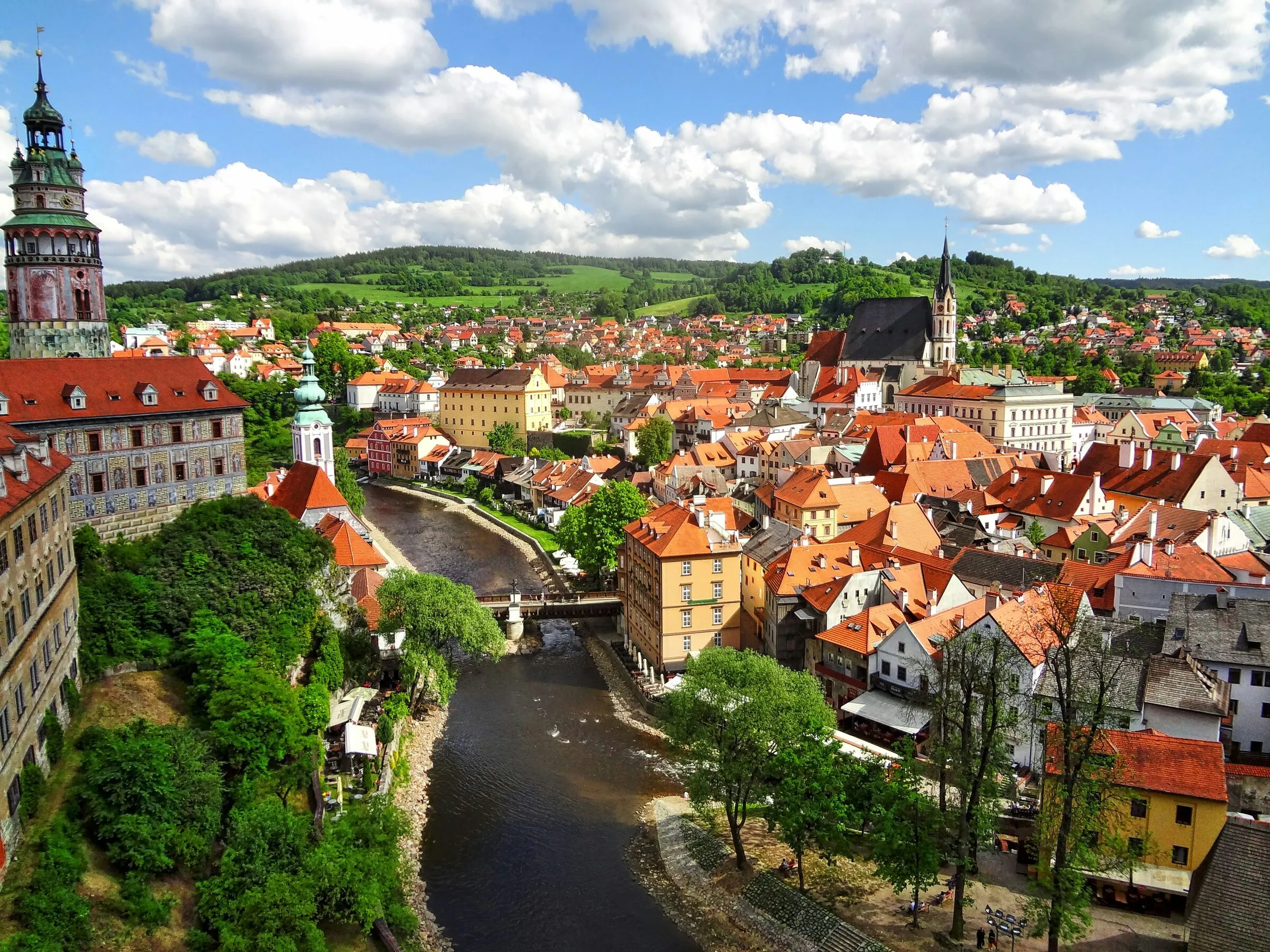 Red rooftops, spires, and the castle above the Vltava River in Prague